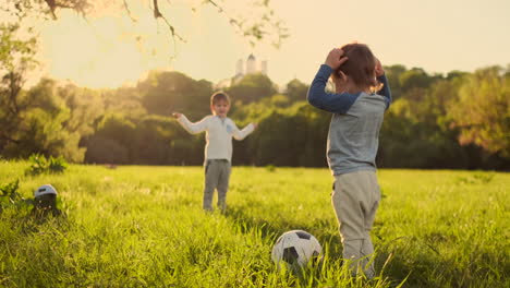 Two-cute-little-kids-playing-football-together-summertime.-Children-playing-soccer-outdoor